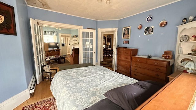 16 Pleasant St, Milo, ME 04463 - bedroom featuring french doors, baseboards, baseboard heating, and wood finished floors