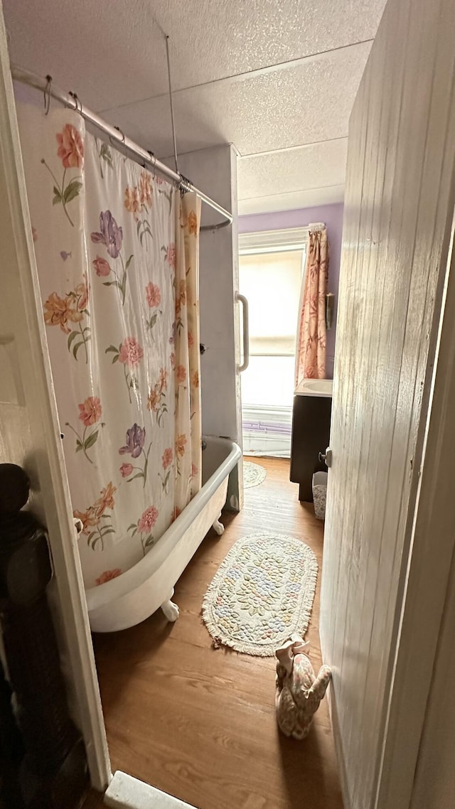 16 Pleasant St, Milo, ME 04463 - full bath featuring wood finished floors, shower / bath combo with shower curtain, and a drop ceiling