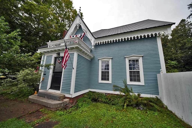 84 Military St, Houlton, ME 04730 - view of property exterior with fence, metal roof, and entry steps