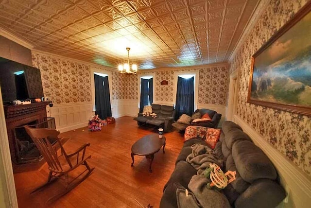 84 Military St, Houlton, ME 04730 - living area with a chandelier, wood finished floors, an ornate ceiling, wainscoting, and crown molding
