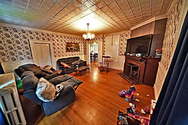 84 Military St, Houlton, ME 04730 - living room with an ornate ceiling, ornamental molding, a fireplace, a chandelier, and a wainscoted wall