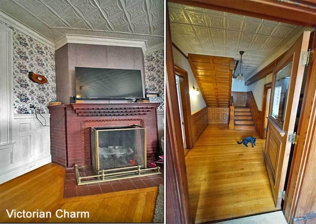 84 Military St, Houlton, ME 04730 - staircase featuring an ornate ceiling, wood-type flooring, wallpapered walls, a brick fireplace, and a wainscoted wall