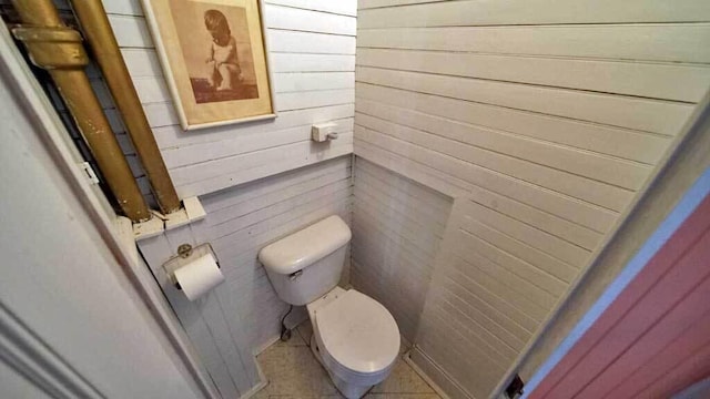 84 Military St, Houlton, ME 04730 - bathroom featuring toilet, wood walls, and tile patterned flooring
