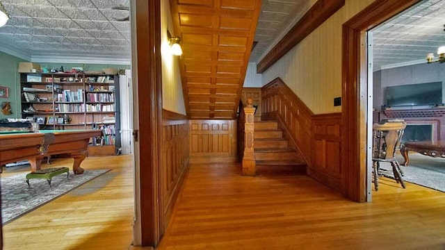 84 Military St, Houlton, ME 04730 - hallway featuring wood finished floors, an ornate ceiling, stairway, ornamental molding, and wood walls