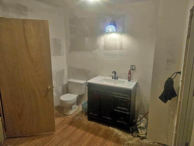 84 Military St, Houlton, ME 04730 - bathroom with wood finished floors, toilet, and vanity