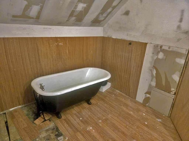 84 Military St, Houlton, ME 04730 - bathroom featuring a freestanding tub, wooden walls, and wood finished floors