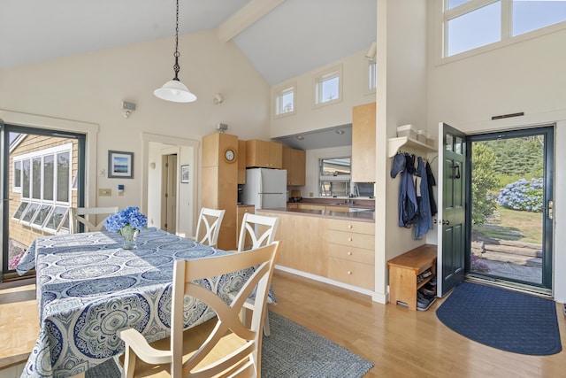 223 Pemaquid Trl, Bristol, ME 04554 - dining area with high vaulted ceiling, light wood-style floors, and beamed ceiling