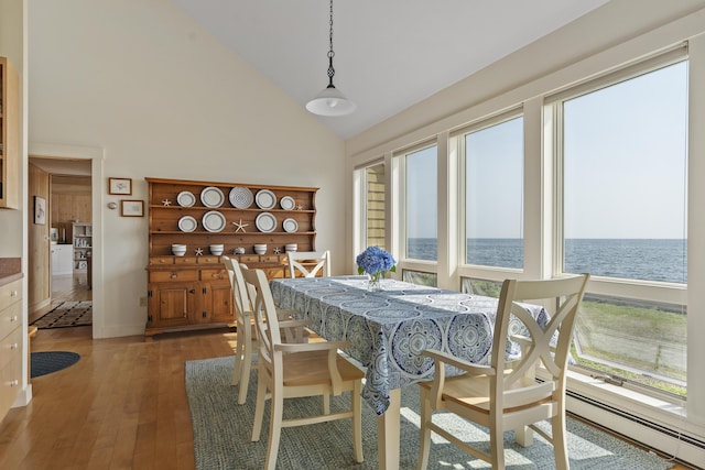 223 Pemaquid Trl, Bristol, ME 04554 - dining space featuring a water view, high vaulted ceiling, baseboard heating, hardwood / wood-style floors, and baseboards
