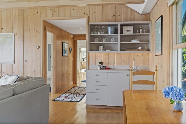 223 Pemaquid Trl, Bristol, ME 04554 - kitchen featuring wooden walls, light wood-style floors, open shelves, lofted ceiling, and a sink