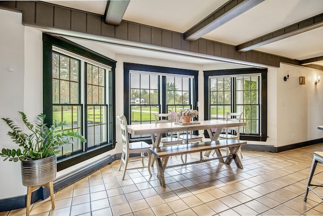 dining room featuring light tile patterned flooring, beamed ceiling, and plenty of natural light