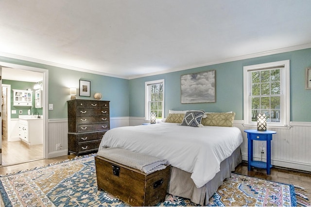 bedroom featuring crown molding, wood finished floors, and wainscoting