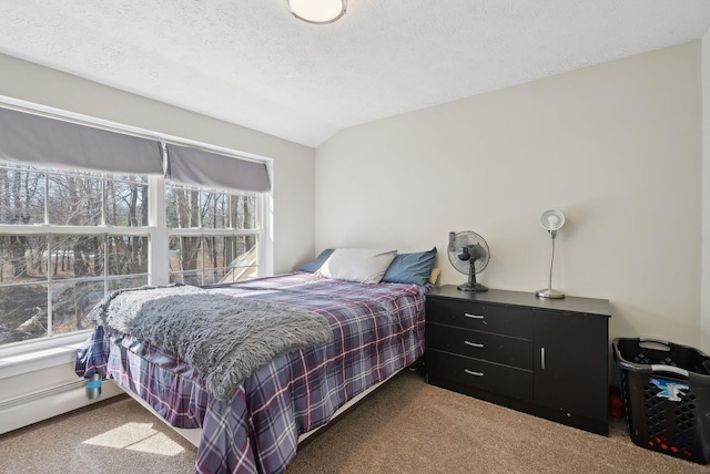 carpeted bedroom with a textured ceiling and vaulted ceiling