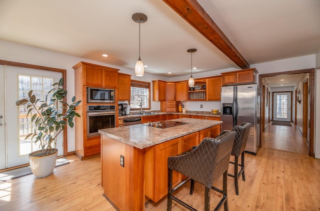 575 Hallowell Rd, Chelsea, ME 04330 - kitchen featuring stainless steel appliances, a sink, a center island, light wood-style floors, and brown cabinets