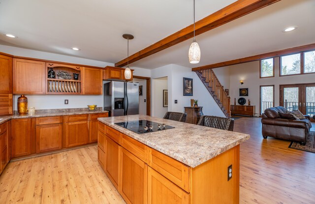575 Hallowell Rd, Chelsea, ME 04330 - kitchen with stainless steel fridge, black electric stovetop, light wood-type flooring, open shelves, and a kitchen island