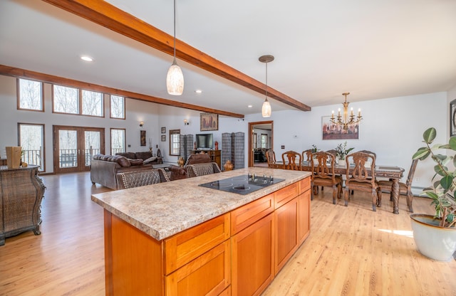575 Hallowell Rd, Chelsea, ME 04330 - kitchen featuring black electric stovetop, light wood-type flooring, beamed ceiling, light countertops, and pendant lighting