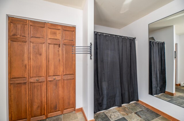 575 Hallowell Rd, Chelsea, ME 04330 - bathroom featuring baseboards, stone finish floors, and a shower with shower curtain