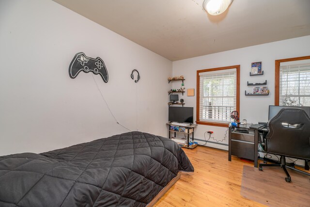 575 Hallowell Rd, Chelsea, ME 04330 - bedroom with multiple windows, light wood-style flooring, a baseboard heating unit, and an office area