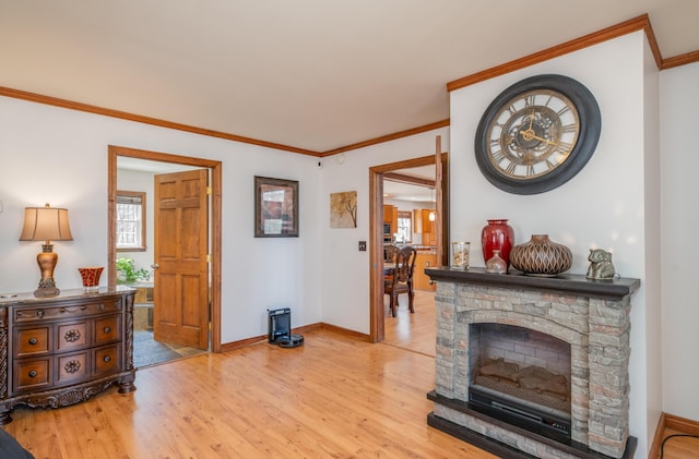 575 Hallowell Rd, Chelsea, ME 04330 - living area with light wood-style floors, crown molding, baseboards, plenty of natural light, and a fireplace