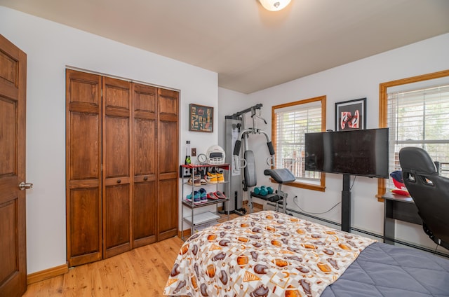 575 Hallowell Rd, Chelsea, ME 04330 - bedroom with multiple windows, light wood-type flooring, a closet, and baseboards