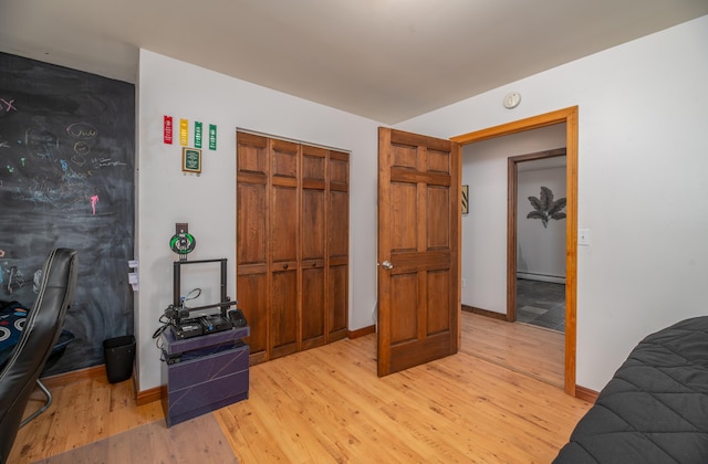 575 Hallowell Rd, Chelsea, ME 04330 - bedroom with light wood-style floors, baseboards, a closet, and a baseboard radiator