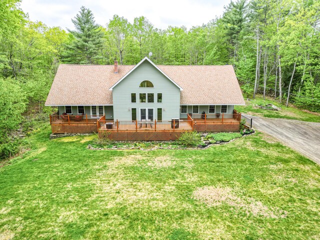 575 Hallowell Rd, Chelsea, ME 04330 - back of property featuring a forest view, a yard, a wooden deck, a shingled roof, and a chimney