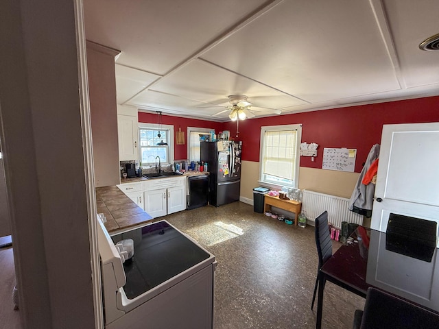 kitchen with freestanding refrigerator, white cabinetry, dishwasher, range with electric cooktop, and plenty of natural light