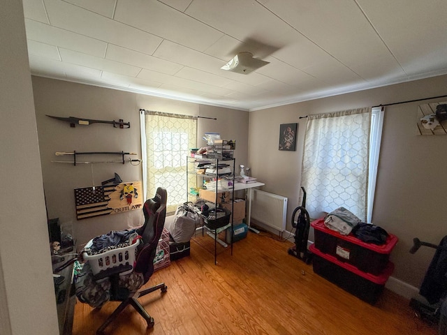 office featuring radiator heating unit, crown molding, and wood finished floors