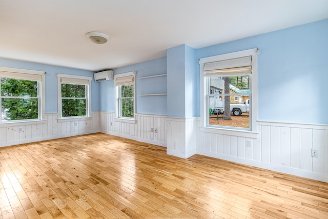 480 E Shore Dr, Acton, ME 04001 - empty room with a wall mounted AC, light wood-style flooring, and a wainscoted wall