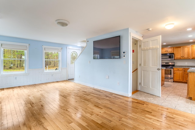 480 E Shore Dr, Acton, ME 04001 - unfurnished living room with light wood-style floors and a wainscoted wall