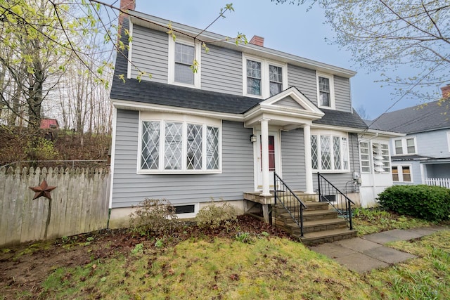dutch colonial featuring a chimney and fence