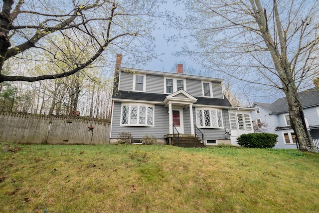 colonial inspired home featuring a chimney and entry steps