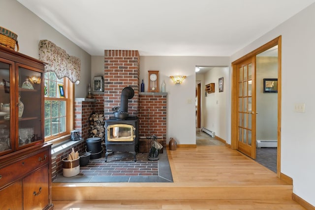 14 Stonebrook Rd, Windham, ME 04062 - living area featuring a baseboard radiator, wood finished floors, a wood stove, and baseboards