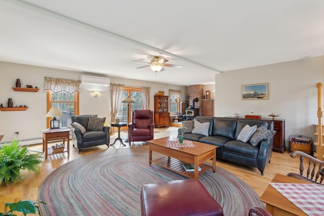 14 Stonebrook Rd, Windham, ME 04062 - living room with a wood stove, a wall unit AC, light wood-style flooring, and a ceiling fan