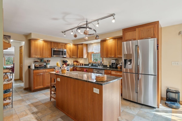 14 Stonebrook Rd, Windham, ME 04062 - kitchen featuring appliances with stainless steel finishes, a center island, brown cabinetry, and dark stone counters