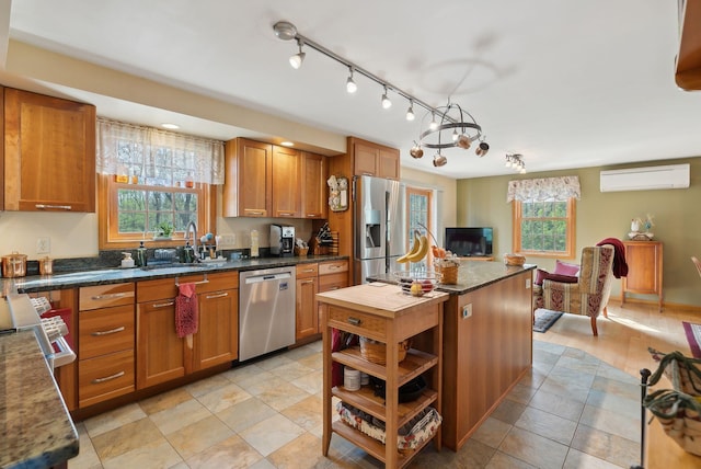 14 Stonebrook Rd, Windham, ME 04062 - kitchen with appliances with stainless steel finishes, an AC wall unit, brown cabinetry, a sink, and open shelves