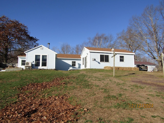 back of property with a yard and a shingled roof