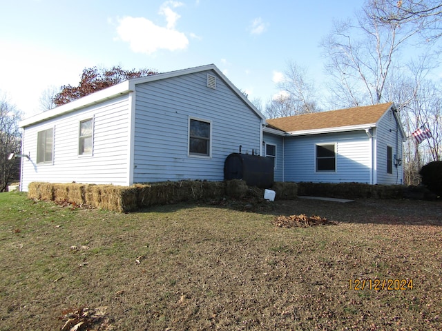 view of side of home featuring a yard and heating fuel