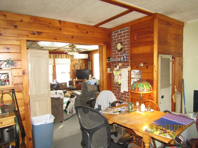 dining room with a wall mounted AC, wooden walls, a textured ceiling, carpet floors, and ceiling fan