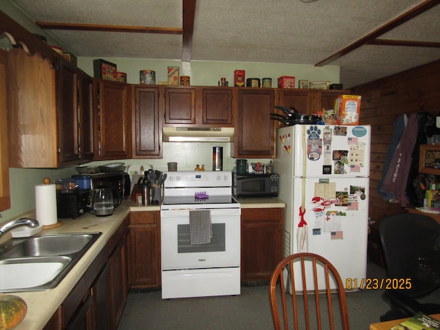kitchen with white appliances, a textured ceiling, under cabinet range hood, light countertops, and a sink