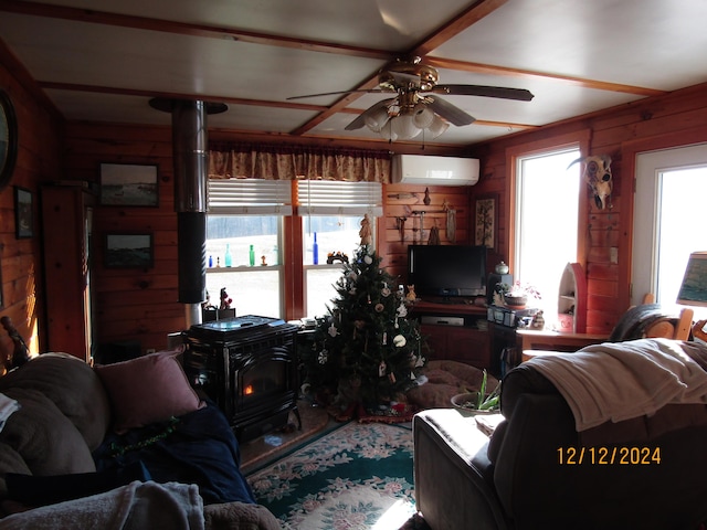 living room featuring a wood stove, wooden walls, an AC wall unit, and ceiling fan