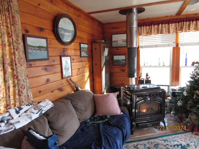 living area with a wood stove and wooden walls