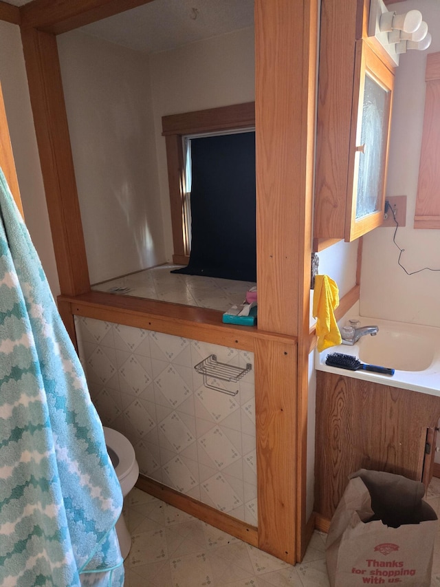 bathroom with a sink, tile patterned floors, and toilet