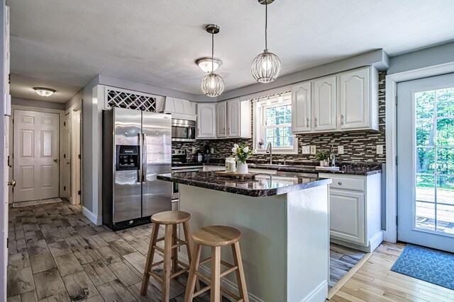 18 Sheila Cir, Saco, ME 04072 - kitchen featuring appliances with stainless steel finishes, light wood-type flooring, backsplash, and plenty of natural light