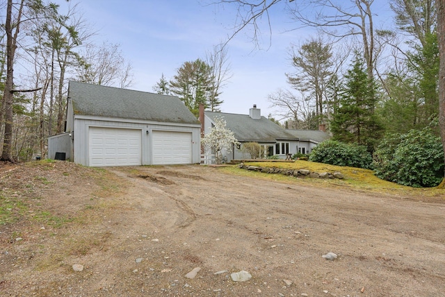 12 Bufflehead Cove Ln, Kennebunk, ME 04043 - view of front of home featuring dirt driveway, a chimney, and roof with shingles