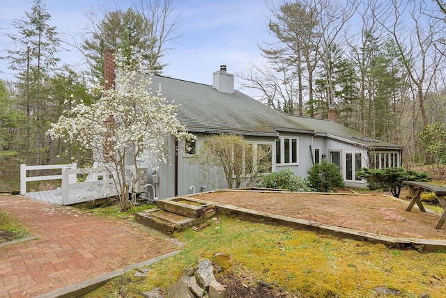 12 Bufflehead Cove Ln, Kennebunk, ME 04043 - back of house with a chimney, a deck, and roof with shingles