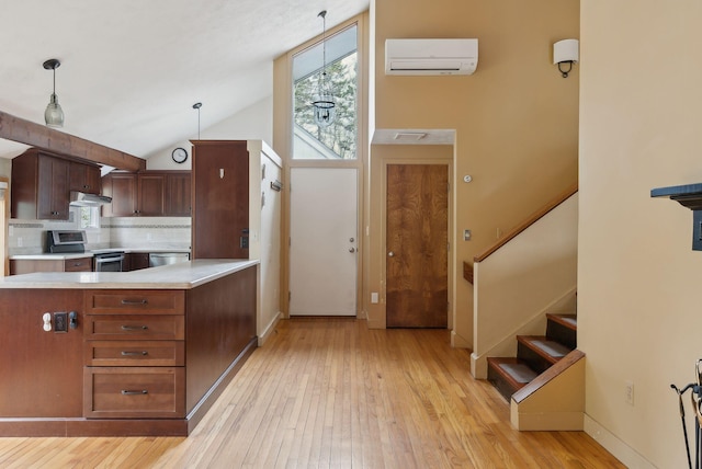 12 Bufflehead Cove Ln, Kennebunk, ME 04043 - kitchen featuring light wood-type flooring, a wall mounted AC, decorative backsplash, light countertops, and appliances with stainless steel finishes