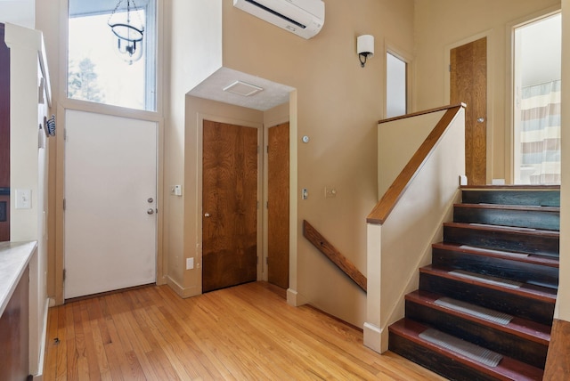12 Bufflehead Cove Ln, Kennebunk, ME 04043 - entryway featuring stairway, light wood-style flooring, and a wall mounted AC