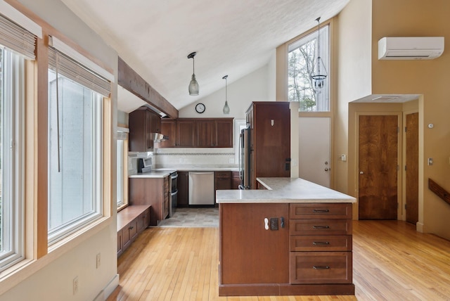 12 Bufflehead Cove Ln, Kennebunk, ME 04043 - kitchen with light wood finished floors, stainless steel appliances, light countertops, and a wall unit AC
