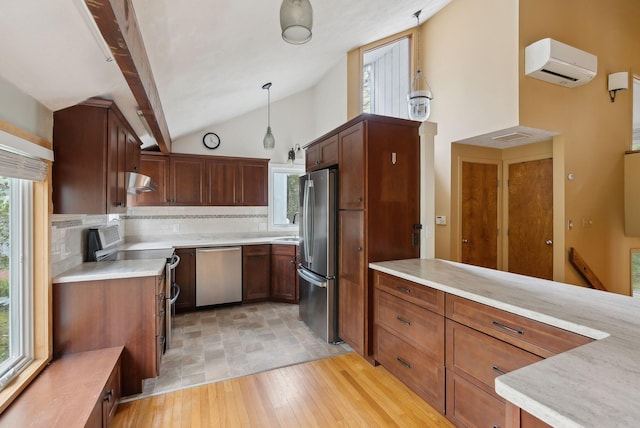 12 Bufflehead Cove Ln, Kennebunk, ME 04043 - kitchen featuring a wall mounted air conditioner, stainless steel appliances, backsplash, under cabinet range hood, and lofted ceiling