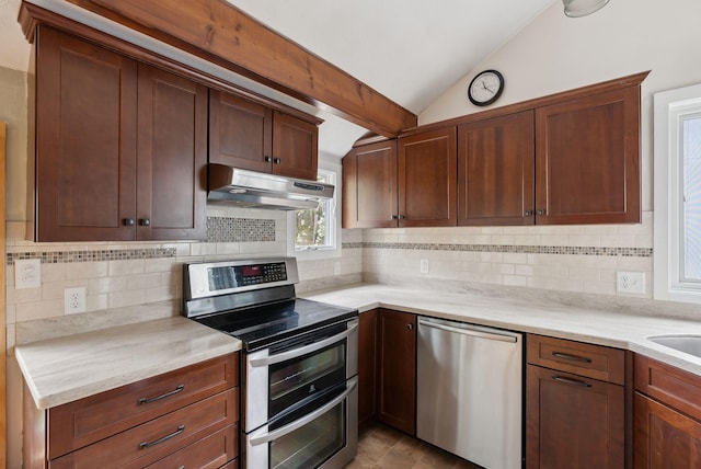 12 Bufflehead Cove Ln, Kennebunk, ME 04043 - kitchen featuring under cabinet range hood, appliances with stainless steel finishes, vaulted ceiling, and tasteful backsplash